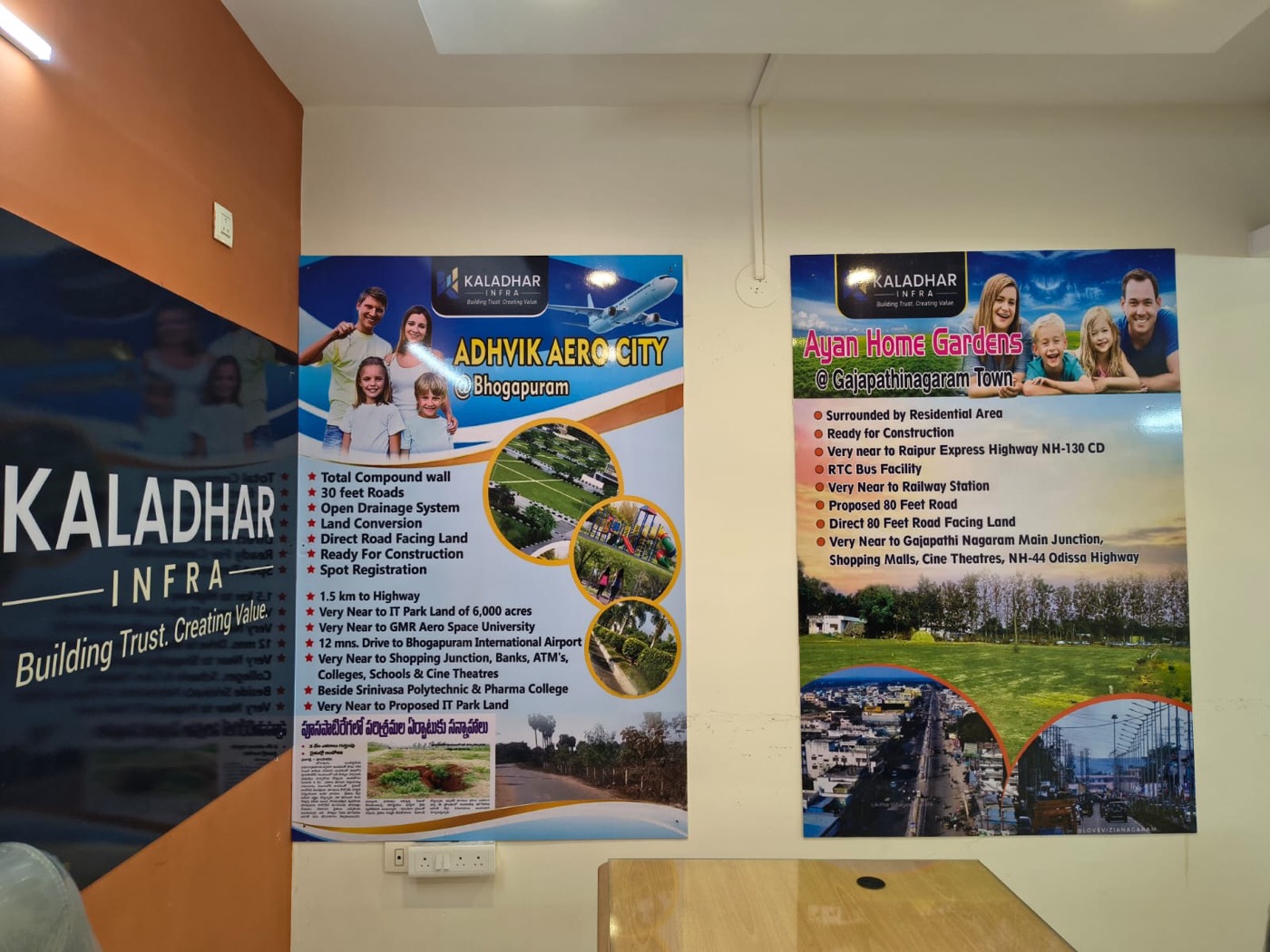 The Kaladhar Infra office wall with the Adhvik Aero City and Ayan Home Gardens project boards